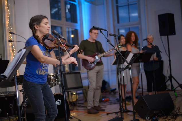 Image depicts VCFA faculty and students performing at the songwriters' showcase